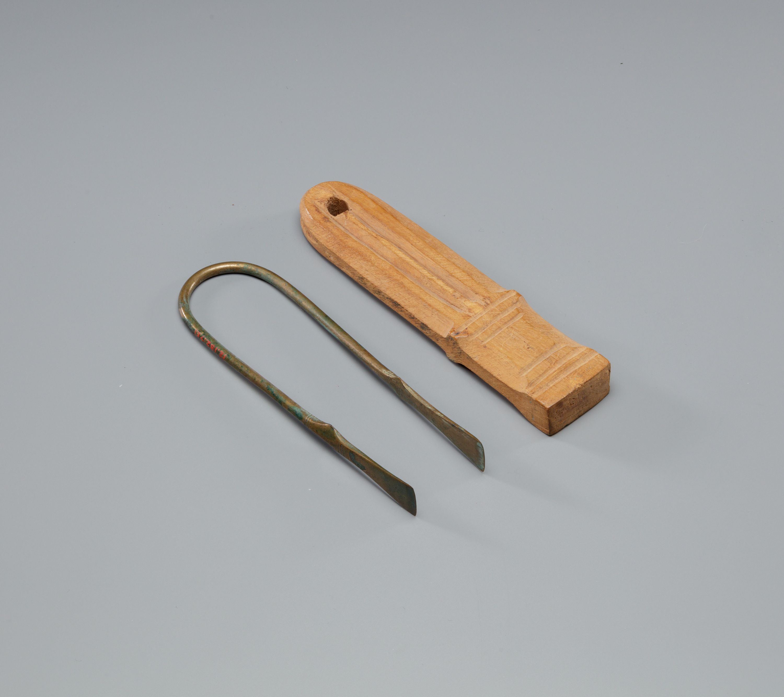 Tweezers Mounted on a Wood Block